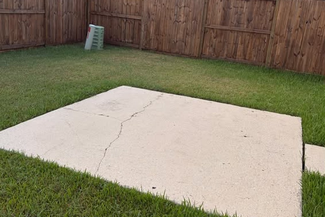 Backyard concrete patio and fence after cleaning