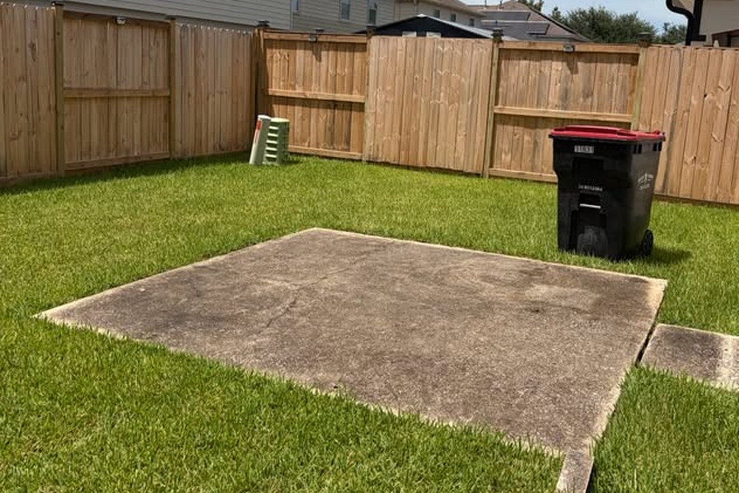 Backyard concrete patio and fence before cleaning